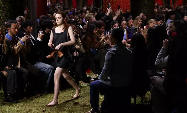 A model holds their shoes during the Miu Miu Fall/Winter 2026-2027 Women's collection presentation in Paris, Tuesday, March 10, 2026. (AP Photo/Tom Nicholson)
