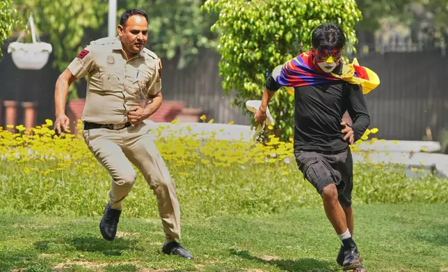 A policeman chases an activist from the Tibetan Youth Congress (TYC) during a protest to commemorate the Tibetan Uprising Day outside the Chinese Embassy in New Delhi, India, Tuesday, March 10, 2026. (AP Photo/Manish Swarup)