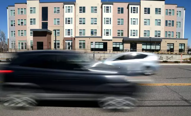 Vehicles pass by the Sapling Grove Apartments, an affordable housing complex, in Aurora, Colo., Friday, March 20, 2026. (AP Photo/Thomas Peipert)