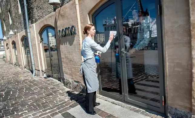 A staff member polishes the glass doors outside a Noma restaurant in Copenhagen, Tuesday, May 1, 2012. (Keld Navntoft/Ritzau Scanpix via AP)