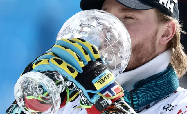 Norway's Atle Lie McGrath kisses the globe trophy for the alpine ski, men's slalom discipline, at the Lillehammer World Cup Finals, in Hafjell, Norway, Wednesday, March 25, 2026. (AP Photo/Gabriele Facciotti)