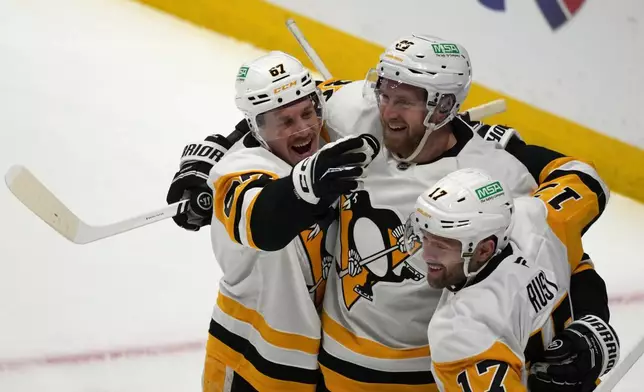 Pittsburgh Penguins right winger Anthony Mantha, center, is congratulated after scoring a goal by right wing Rickard Rakell, left, and right wing Bryan Rust in the first period of an NHL hockey game against the Colorado Avalanche, Monday, March 16, 2026, in Denver. (AP Photo/David Zalubowski)