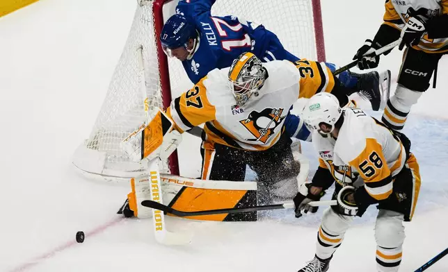 Pittsburgh Penguins goalie Arturs Silvos (37) pins Colorado Avalanche center Parker Kelly (17) to the net as Penguins defenseman Kris Letang (58) looks to clear the puck in the first period of an NHL hockey game Monday, March 16, 2026, in Denver. (AP Photo/David Zalubowski)