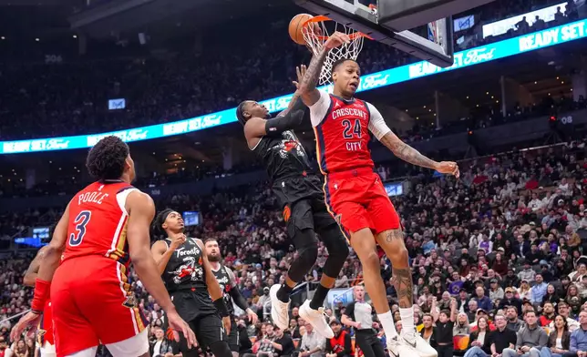 Toronto Raptors' RJ Barrett, second from right, scores against New Orleans Pelicans' Jordan Hawkins (24) during first-half NBA basketball game action in Toronto, Friday March 27 2026. (Chris Young/The Canadian Press via AP)