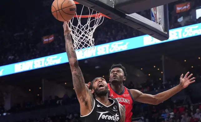 Toronto Raptors' Brandon Ingram, front, plays the ball as New Orleans Pelicans' Yves Missi defends during the first half of an NBA basketball game in Toronto on Friday March 27, 2026. (Chris Young/The Canadian Press via AP)