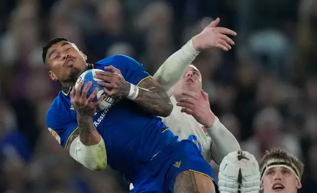 Italy's Monty Ioane, left, is challenged by England's Tommy Roebuck during the Six Nations rugby union match between Italy and England in Rome, Saturday, March 7, 2026. (AP Photo/Gregorio Borgia)