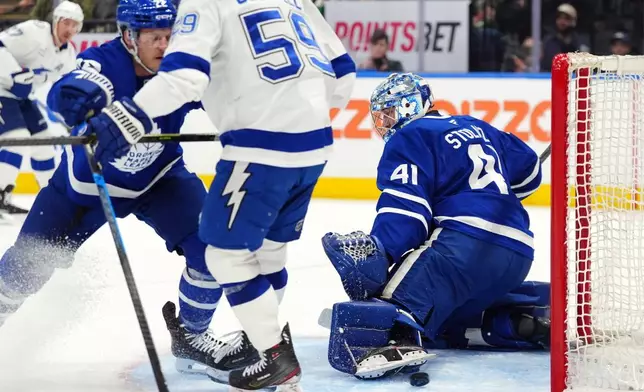 Toronto Maple Leafs' goaltender Anthony Stolarz (41) makes a save as teammate Jake McCabe (22) and Tampa Bay Lightning's Jake Guentzel (59) battle during the first period of an NHL hockey game in Toronto, Saturday, March 7, 2026. (Frank Gunn/The Canadian Press via AP)