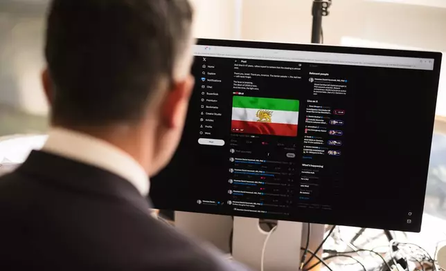 Dr. Houman David Hemmati poses for photos with his social media page displayed on a screen in Santa Monica, Calif., Wednesday, March 11, 2026. (AP Photo/Jae C. Hong)