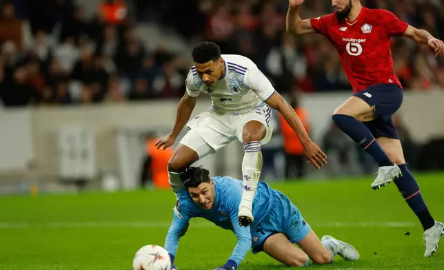 Aston Villa's Ollie Watkins falls over Lille's goalkeeper Berke Ozer during a first leg, round of 16 Europa League soccer match between Lille and Aston Villa in Lille, France, Sunday, Feb. 22, 2026. (AP Photo/Jean-Francois Badias)