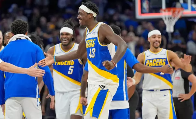 Indiana Pacers forward Pascal Siakam (43) celebrates with teammates including forward Jarace Walker (5) and guard Andrew Nembhard, right, after defeating the Orlando Magic in an NBA basketball game, Monday, March 23, 2026, in Orlando, Fla. (AP Photo/John Raoux)