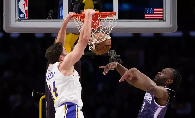 Los Angeles Lakers forward Maxi Kleber, left, dunks past Sacramento Kings forward Precious Achiuwa during the first half of an NBA basketball game in Los Angeles, Sunday, March 1, 2026. (AP Photo/Kyusung Gong)