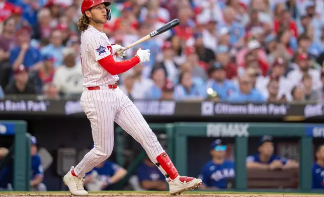 Philadelphia Phillies' Alec Bohm hits a three-run home rum during the fifth inning of an opening-day baseball game against the Texas Rangers, Thursday, March 26, 2026, in Philadelphia. (AP Photo/Chris Szagola)