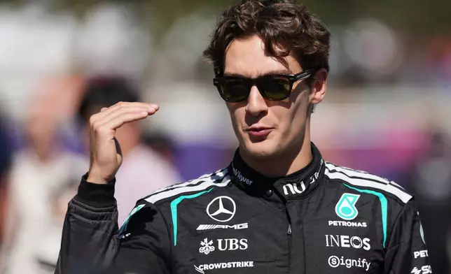 Mercedes driver George Russell of Britain gestures as he walks down the F1 Paddock ahead of the Australian Formula One Grand Prix at Albert Park, in Melbourne, Australia, Thursday, March 5, 2026. (AP Photo/Heath McKinley)