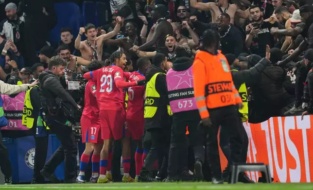 Paris Saint-Germain players celebrate after PSG's Khvicha Kvaratskhelia scored his side's opening goal during the Champions League soccer match between Chelsea and Paris Saint-Germain in London, England, Tuesday, March 17, 2026. (AP Photo/Kin Cheung)