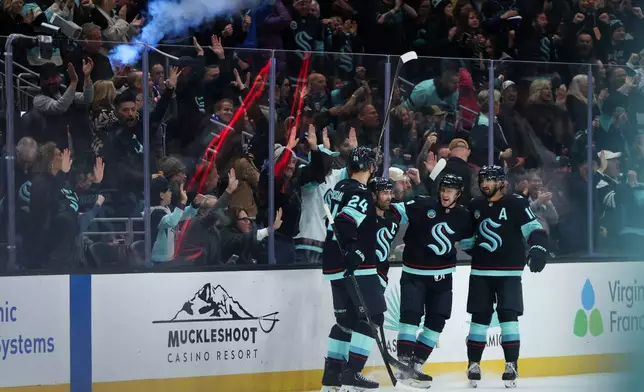 Members of the Seattle Kraken gather around Seattle Kraken right wing Jordan Eberle (7) after scoring a goal in the second period against the Vancouver Canucks during an NHL hockey game Saturday, Feb. 28, 2026, in Seattle. (AP Photo/Kevin Ng)