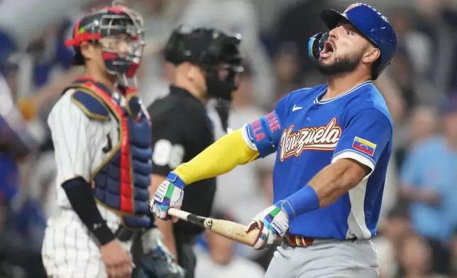 Venezuela's Wilyer Abreu celebrates with his teammates after he hit a home run during the six inning of a World Baseball Classic quarterfinal game against Japan, Saturday, March 14, 2026, in Miami. (AP Photo/Lynne Sladky)