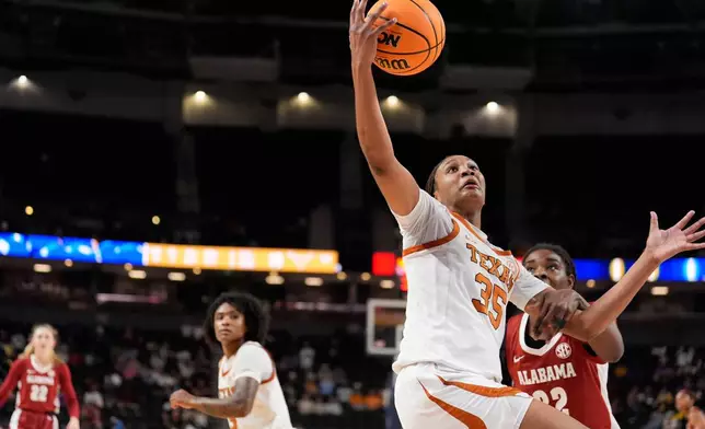Texas forward Madison Booker vies for the ball with Alabama forward Alancia Ramsey during first half of an NCAA college basketball game in the quarterfinals of the Southeastern Conference tournament, Friday, March 6, 2026, in Greenville, S.C. (AP Photo/Chris Carlson)