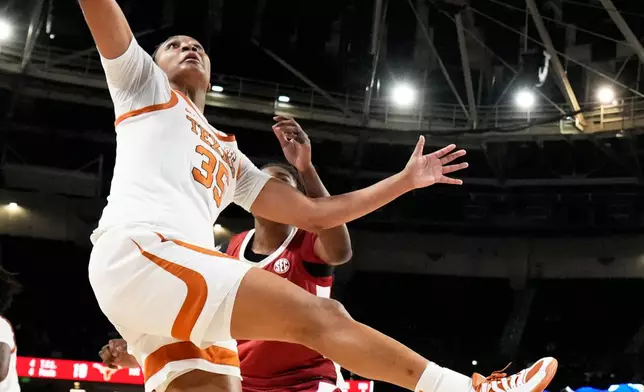 Texas forward Madison Booker vies for the ball with Alabama forward Alancia Ramsey during first half of an NCAA college basketball game in the quarterfinals of the Southeastern Conference tournament, Friday, March 6, 2026, in Greenville, S.C. (AP Photo/Chris Carlson)
