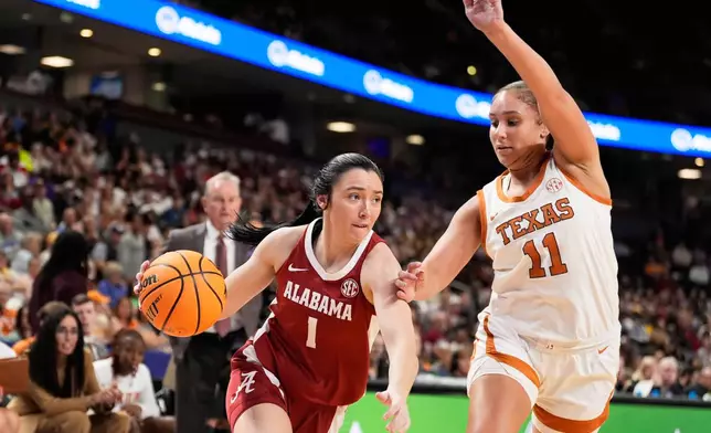Alabama guard Ace Austin drives to the basket past Texas forward Justice Carlton during first half of an NCAA college basketball game in the quarterfinals of the Southeastern Conference tournament, Friday, March 6, 2026, in Greenville, S.C. (AP Photo/Chris Carlson)