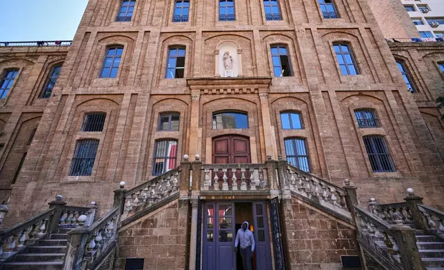 A displaced migrant man who among many others fled Israeli strikes in southern and eastern Lebanon and Beirut's southern suburbs, steps out from the basement of Saint Joseph Church, which has been turned into a shelter for displaced migrants, mostly from African nations, in Beirut, Wednesday, March 11, 2026. (AP Photo/Hussein Malla)
