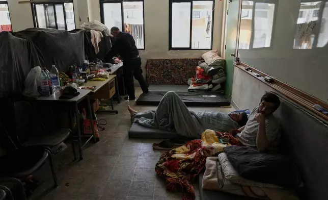 Displaced people fleeing Israeli airstrikes in southern Lebanon settle at the Bir Hassan Technical Institute, which has been turned into a shelter, in Beirut, Lebanon, Wednesday, March 11, 2026. (AP Photo/Bilal Hussein)