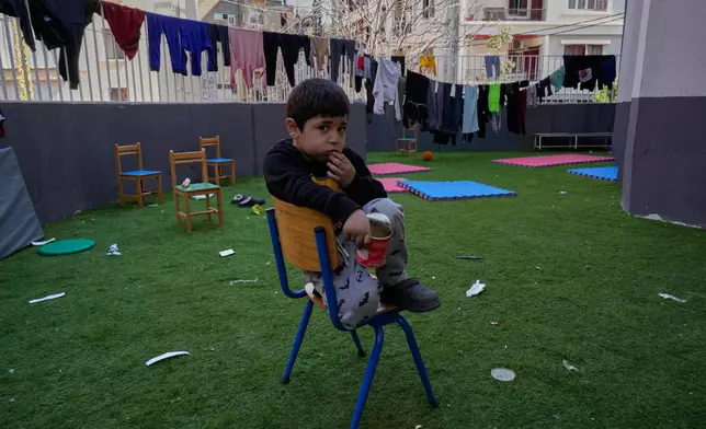 A displaced boy who fled Israeli strikes in southern Lebanon with his family sits on the backyard school that turned into a shelter in Beirut, Lebanon, Tuesday, March 10, 2026. (AP Photo/Hussein Malla)