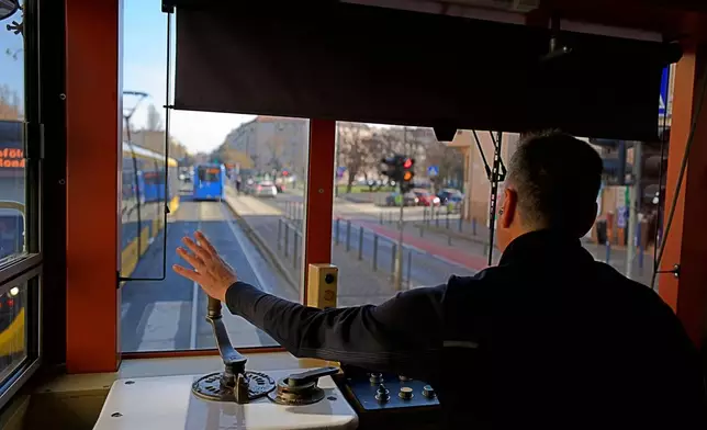 A driver waves while operating a century-old freight tram in Budapest, Hungary on Thursday, March 12, 2026. (AP Photo/Bela Szandelszky)