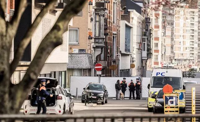 Police stand near barricades as they secure an area after a blast took place near a synagogue, in Liege, Belgium, Monday, March 9, 2026. (AP Photo/Valentin Bianchi)