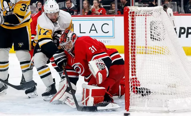 Pittsburgh Penguins' Bryan Rust (17) looses control of the puck as he collides with Carolina Hurricanes goaltender Frederik Andersen (31) during the third period of an NHL hockey game in Raleigh, N.C., Wednesday, March 18, 2026. (AP Photo/Karl DeBlaker)