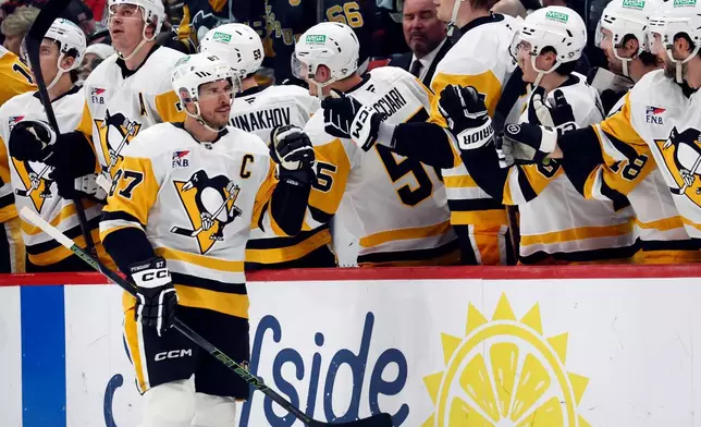 Pittsburgh Penguins' Sidney Crosby (87) celebrates his goal along the bench during the second period of an NHL hockey game against the Carolina Hurricanes in Raleigh, N.C., Wednesday, March 18, 2026. (AP Photo/Karl DeBlaker)