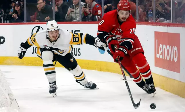 Carolina Hurricanes' Sebastian Aho (20) controls the puck in front of Pittsburgh Penguins' Rickard Rakell (67) during the third period of an NHL hockey game in Raleigh, N.C., Wednesday, March 18, 2026. (AP Photo/Karl DeBlaker)