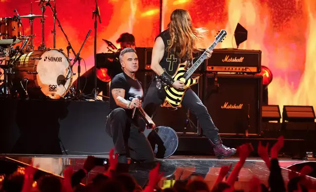 Robbie Williams, centre left performs during the Brit Awards 2026 in Manchester, England, Saturday, Feb. 28, 2026. (Photo by Scott A Garfitt/Invision/AP)
