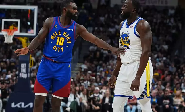 Denver Nuggets guard Tim Hardaway Jr., left, exchanges words with Golden State Warriors forward Draymond Green in the first half of an NBA basketball game Sunday, March 29, 2026, in Denver. (AP Photo/David Zalubowski)