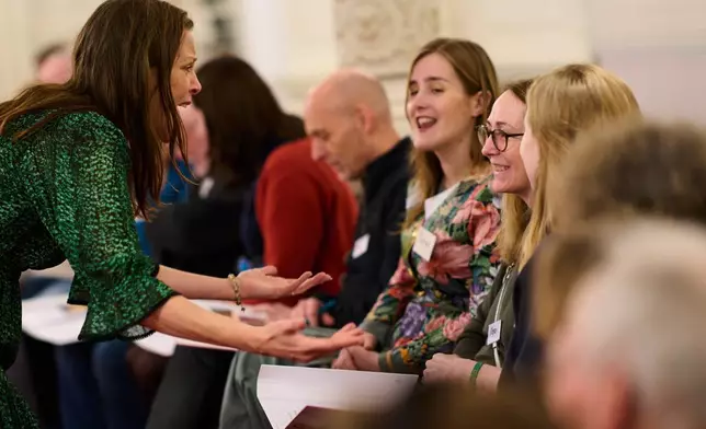 Megan Worthy, with glasses, right, and opera singer Maartje de Lint, left, and others, many of them seniors with a form of dementia, join in the "singing circle" at the Concertgebouw's ornate Mirror Hall in Amsterdam, on Feb. 24, 2026. (AP Photo/Peter Dejong)