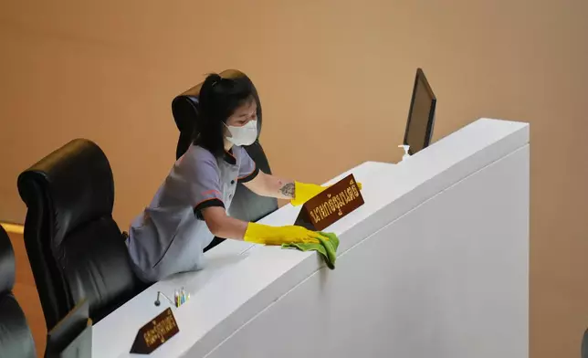 A worker cleans the desk for Thai Prime Minister Anutin Charnvirakul at the parliament in Bangkok, Thailand, Thursday, March 19, 2026. (AP Photo/Sakchai Lalit)