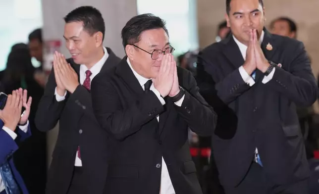 Pheu Thai party leader Julapun Amornvivat, center, gesture as he arrives at the parliament in Bangkok, Thailand, Thursday, March 19, 2026. (AP Photo/Sakchai Lalit)