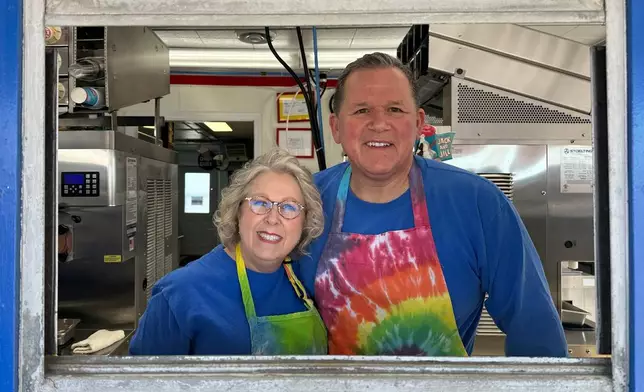 Moorhead Dairy Queen owners Diane, left, and Troy DeLeon pose for a photo Sunday, March 1, 2026, at the walk-up window of their Dairy Queen in Moorhead, Minn. (AP Photo/Jack Dura)