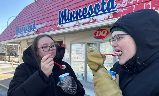 Koral Salisbury, left, and Ally Hoekstra eat ice cream treats Sunday, March 1, 2026, at the Dairy Queen in Moorhead, Minn. (AP Photo/Jack Dura)