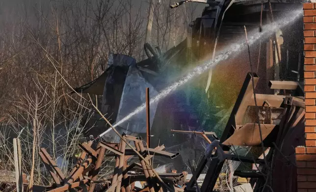 Firefighters put out the fire at railway workshops following a Russia missile and drone attack, in Brovary close to Kyiv, Ukraine, Saturday, March 14, 2026. (AP Photo/Efrem Lukatsky)