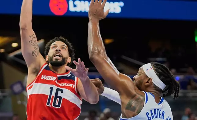 Washington Wizards forward Anthony Gill (16) shoots over Orlando Magic center Wendell Carter Jr. (34) during the first half of an NBA basketball game, Thursday, March 12, 2026, in Orlando, Fla. (AP Photo/John Raoux)