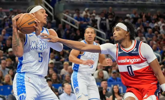Orlando Magic forward Paolo Banchero (5) grabs a rebound in front of Washington Wizards guard Bilal Coulibaly (0) during the first half of an NBA basketball game, Thursday, March 12, 2026, in Orlando, Fla. (AP Photo/John Raoux)