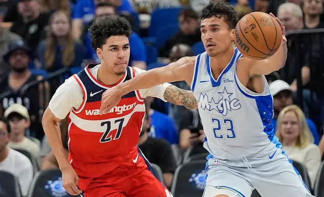 Orlando Magic forward Tristan da Silva (23) grabs a loose ball in front of Washington Wizards guard Will Riley (27) during the first half of an NBA basketball game, Thursday, March 12, 2026, in Orlando, Fla. (AP Photo/John Raoux)