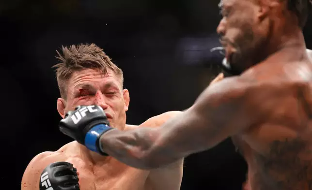 Drew Dober, left, connects with a punch that knocks down Michael Johnson, right, in the second round of a lightweight mixed martial arts bout during UFC 326, Saturday, March 7, 2026, in Las Vegas. (Steve Marcus/Las Vegas Sun via AP)
