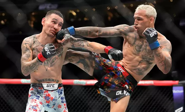 Charles Oliveira, right, punches Max Holloway in a lightweight fight during UFC 326 Saturday, March 7, 2026, in Las Vegas. (Steve Marcus/Las Vegas Sun via AP)/Las Vegas Sun via AP)
