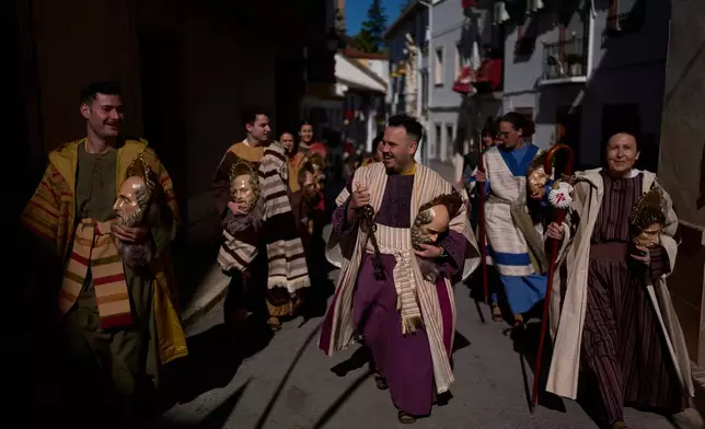 Penitents of the 'Pollinita' brotherhood, dressed in a typical Apostle costumes take part during the Holy Week procession in Cabra, southern Spain, Sunday, March 29, 2026. (AP Photo/Manu Fernandez)