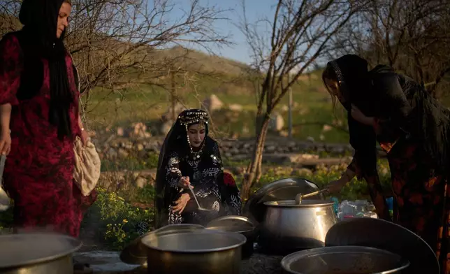 Women wearing traditional clothes prepare Iftar meal as they take part in a family gathering during the Muslim holy month of Ramadan in the village of Gulp, Iraq, Tuesday, March 17, 2026. (AP Photo/Leo Correa)