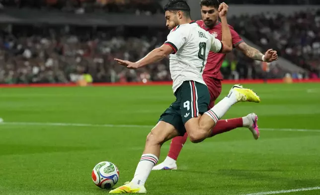 Mexico's Raul Jimenez, front, passes the ball during the international friendly soccer match between Mexico and Portugal in Mexico City, Saturday, March 28, 2026. (AP Photo/Eduardo Verdugo)