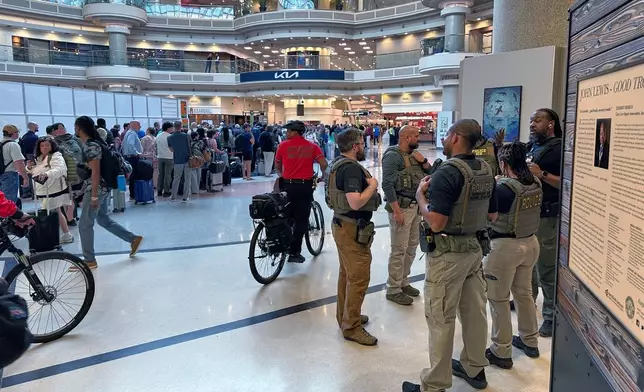 Federal immigration agents are seen at the Hartsfield-Jackson Atlanta International Airport, Monday, March 23, 2026, in Atlanta. (AP Photo/Emilie Megnien)