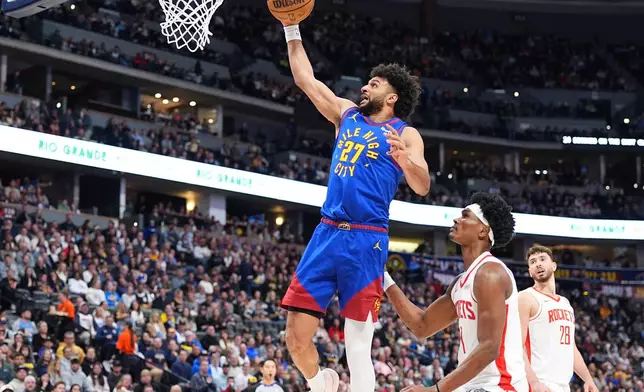 Denver Nuggets guard Jamal Murray, left, drives to the rim past Houston Rockets forward Amen Thompson in the first half of an NBA basketball game, Wednesday, March 11, 2026, in Denver. (AP Photo/David Zalubowski)