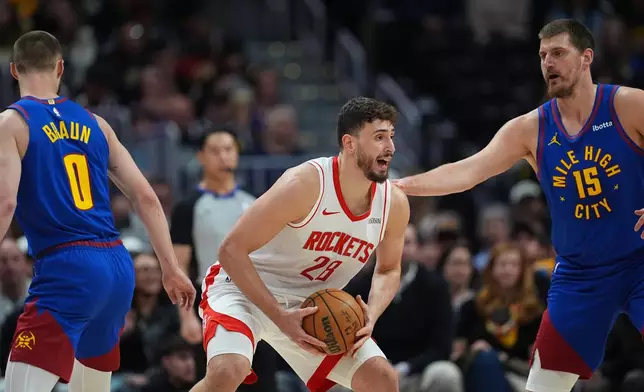 Houston Rockets center Alperen Sengun, center, looks to pass the ball as Denver Nuggets guard Christian Braun, left, and center Nikola Jokic defend in the first half of an NBA basketball game Wednesday, March 11, 2026, in Denver. (AP Photo/David Zalubowski)